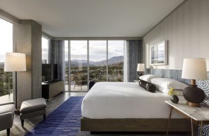 Gay-Friendly Kimpton Rowan Palm Springs Hotel room with a king bed, balcony, and mountain view. Modern design for gay travelers.