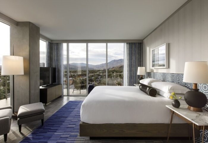 Gay-Friendly Kimpton Rowan Palm Springs Hotel room with a king bed, balcony, and mountain view. Modern design for gay travelers.