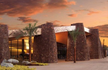 Kimpton Rowan Palm Springs Hotel entrance at sunset. Gay-friendly hotel with modern architecture and palm trees. Palm Springs travel destination.