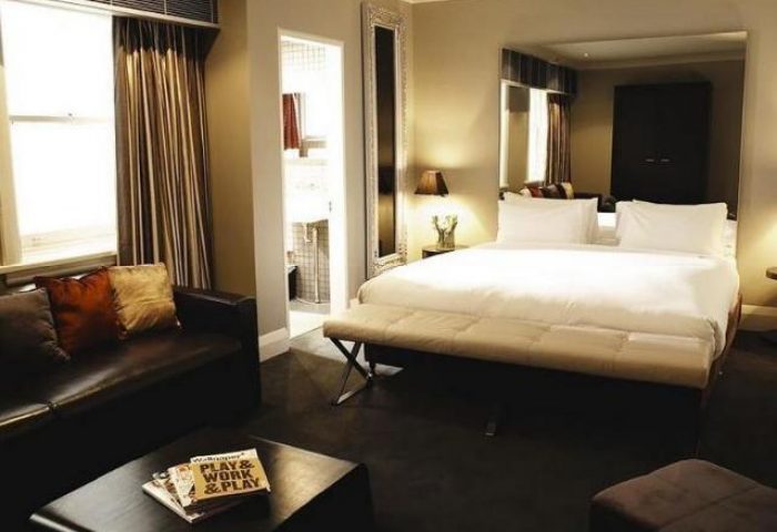 Kirketon Hotel Sydney room. Gay-friendly hotel with a queen bed, leather couch, and bathroom. Modern design for gay men's travel advice.