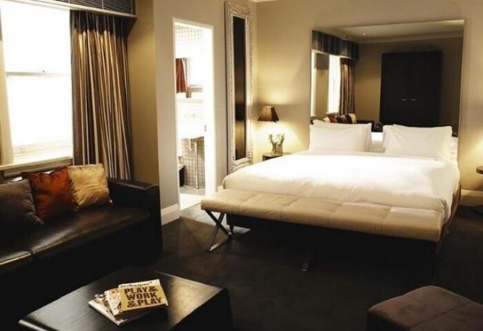 Kirketon Hotel Sydney room. Gay-friendly hotel with a queen bed, leather couch, and bathroom. Modern design for gay men's travel advice.