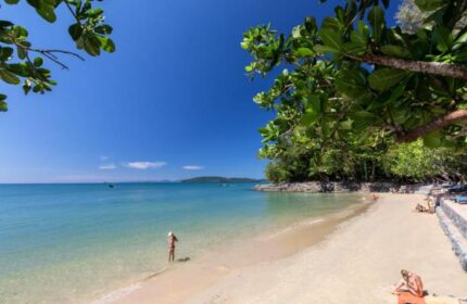 Krabi Resort Pool Villa beach view. Gay-friendly hotel in Krabi, Thailand. Sandy beach, clear water, blue sky, and lush greenery.