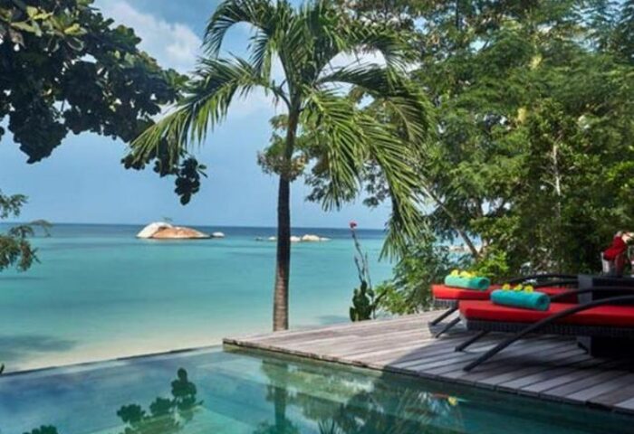 Kupu Kupu Phangan Beach Villas & Spa by L’Occitane: Gay-friendly hotel with pool, ocean view, lounge chairs, and palm trees on Koh Phangan.