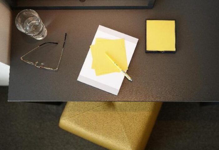 L7 Myeongdong by LOTTE desk view. Note pad, pen, glasses, water, and stool. Gay-friendly hotel in Seoul, South Korea for gay travelers.