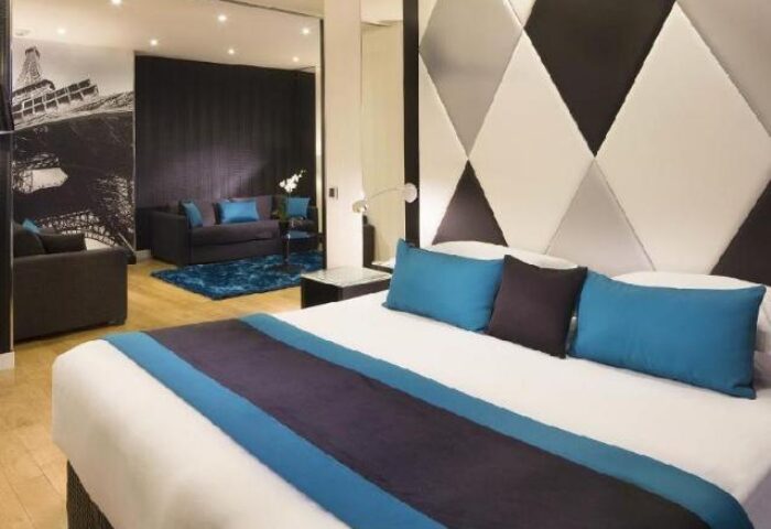 L'Empire Paris Hotel room. Gay-friendly, pet-friendly hotel in Paris. Modern decor, Eiffel Tower art, blue accents. Comfortable stay in Paris.