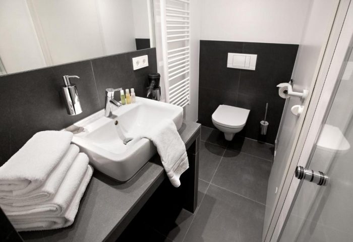 Lindemann's Hotel bathroom. Modern, gay-friendly hotel room with sink, towels, and toilet. Clean design for gay men travelers.