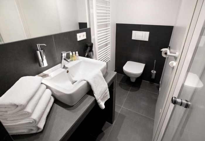 Lindemann's Hotel bathroom. Modern, gay-friendly hotel room with sink, towels, and toilet. Clean design for gay men travelers.