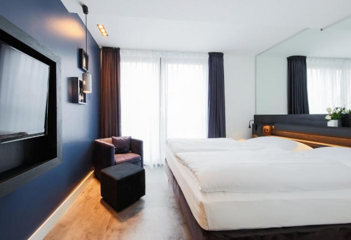 Lindemann's Hotel room. Gay-friendly hotel with a double bed, chair, and TV. Modern design, comfortable for gay travelers. Great for Berlin travel advice.