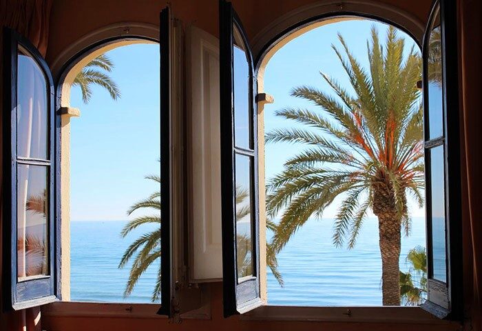 View from La Santa Maria, a gay-friendly hotel. Open window overlooking the sea and palm trees. Ideal for gay men travel advice.