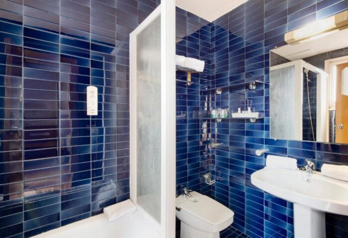 La Santa Maria gay-friendly hotel bathroom. Blue tiled walls, sink, bidet, and shower. Gay travel accommodations.