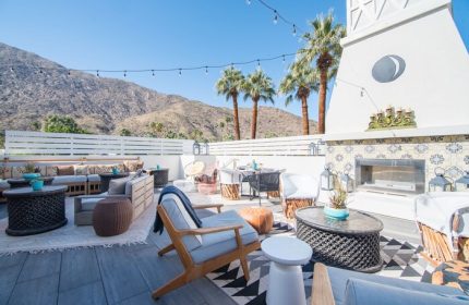 La Serena Villas, a Kirkwood Collection Hotel, gay-friendly hotel patio. Outdoor seating, fireplace, mountain views, and palm trees.