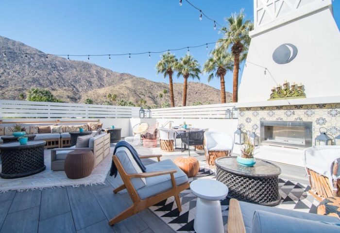 La Serena Villas, a Kirkwood Collection Hotel, gay-friendly hotel patio. Outdoor seating, fireplace, mountain views, and palm trees.