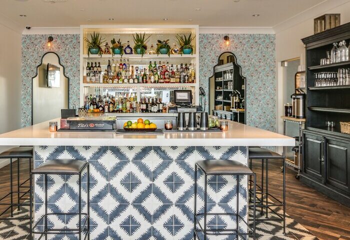 Bar at La Serena Villas, a gay-friendly Kirkwood Collection Hotel. Stylish interior with patterned tiles and fully stocked shelves.