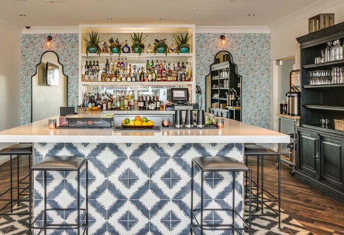 Bar at La Serena Villas, a gay-friendly Kirkwood Collection Hotel. Stylish interior with patterned tiles and fully stocked shelves.