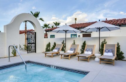 Poolside at La Serena Villas, a gay-friendly hotel. Loungers with umbrellas offer relaxation. Kirkwood Collection Hotel provides luxury travel.