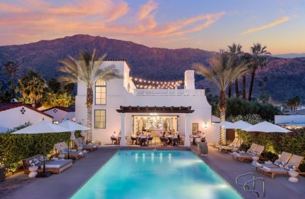 La Serena Villas, A Kirkwood Collection Hotel pool view at dusk. Gay-friendly hotel with bar, lounge chairs, and mountain backdrop. Palm Springs.
