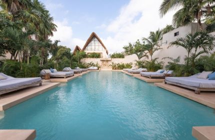 La Valise Tulum's pool scene. Gay-friendly hotel with loungers, palm trees, and unique architecture. Ideal for LGBTQ+ travelers in Tulum.