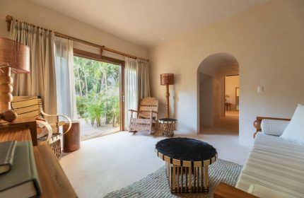 La Valise Tulum gay-friendly hotel room. Interior view with rustic furniture, open to lush greenery. A serene, stylish space.