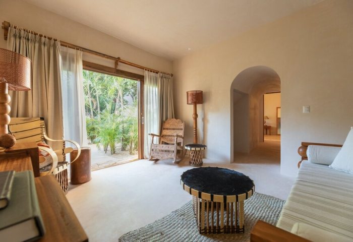 La Valise Tulum gay-friendly hotel room. Interior view with rustic furniture, open to lush greenery. A serene, stylish space.