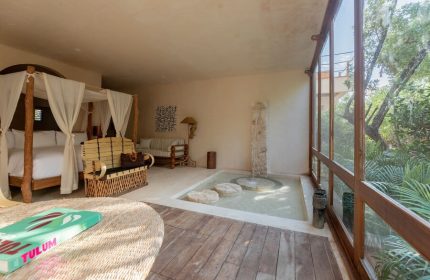 La Valise Tulum gay-friendly hotel room. Canopy bed, indoor fountain, & rustic decor create a luxurious, relaxing vibe. Perfect for gay travel.