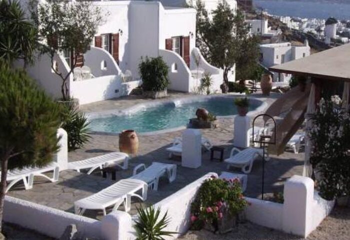 La Veranda of Mykonos Traditional Guesthouse pool. Gay-friendly hotel with white buildings, sunbeds, and sea views. Ideal for gay travel.