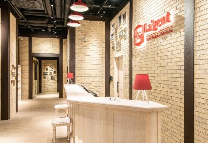 La'gent Hotel Shinjuku Kabukicho lobby. Gay-friendly hotel with stylish design, red lamps, and brick walls. Modern and welcoming space.