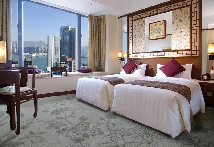 Lan Kwai Fong Hotel @ Kau U Fong room with city view. Gay-friendly hotel room featuring twin beds and a large window overlooking Hong Kong's skyline.