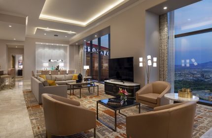 Las Vegas Hilton at Resorts World suite. Upscale gay-friendly hotel living room with city view. Modern design, perfect for LGBT travelers.