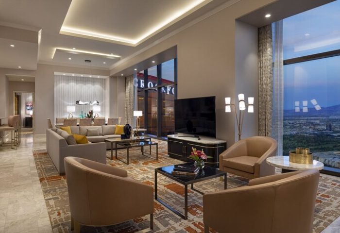 Las Vegas Hilton at Resorts World suite. Upscale gay-friendly hotel living room with city view. Modern design, perfect for LGBT travelers.