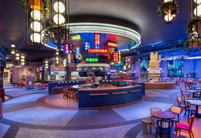 Interior of Gay-Friendly Las Vegas Hilton at Resorts World. Neon signs, bars, tables, and seating create a vibrant, welcoming atmosphere.
