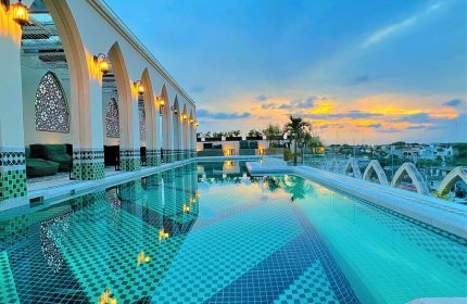 Layla Tulum Adults Only gay-friendly hotel rooftop pool at sunset. Arches, lanterns, and intricate tile work create a luxurious vibe.