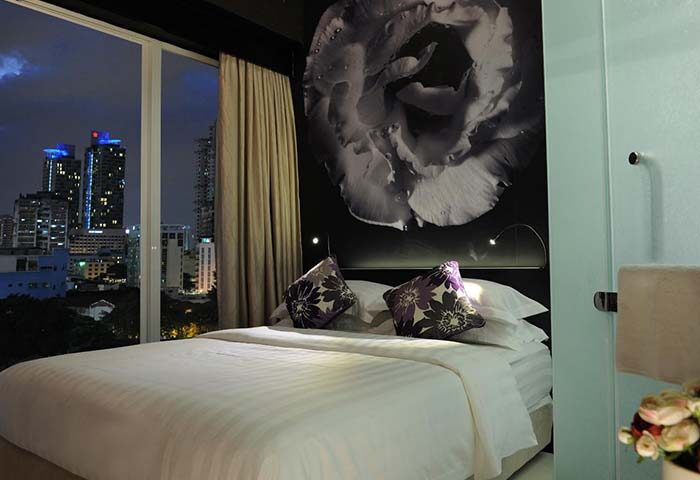 Bedroom at Le Apple Boutique Hotel Bukit Bintang, a gay-friendly hotel. City view, flower art, bed with pillows. For gay travel.