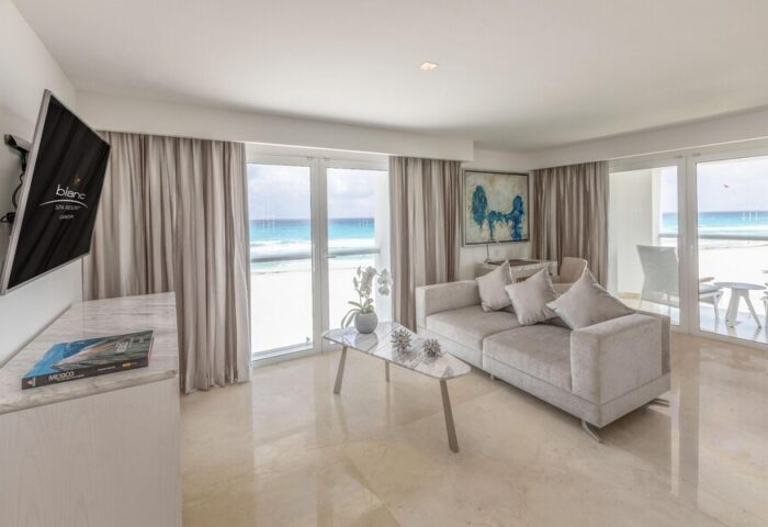Le Blanc Resort Cancun Adults Only All-Inclusive suite. Gay-friendly hotel with ocean view, balcony, couch, and TV. Perfect for gay travel.
