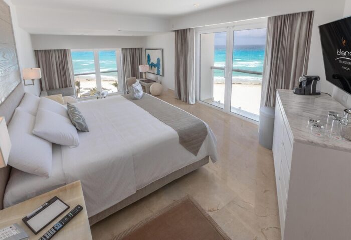 Le Blanc Resort Cancun adults-only all-inclusive gay-friendly hotel. Ocean view room with king bed and balcony overlooking turquoise water.