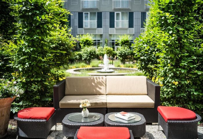 Le Méridien Munich gay-friendly hotel outdoor seating area. Fountain view, perfect for relaxing. A peaceful oasis in Munich, Germany.