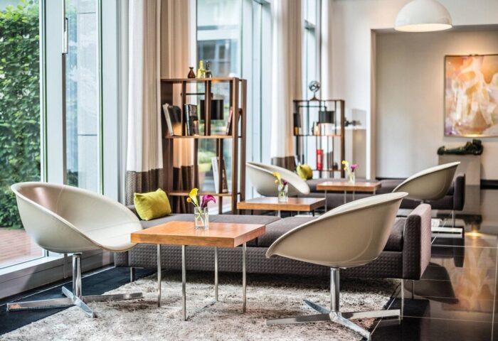 Le Méridien Munich's stylish lounge area. This gay-friendly hotel features modern seating, bookshelves, and bright, airy spaces.
