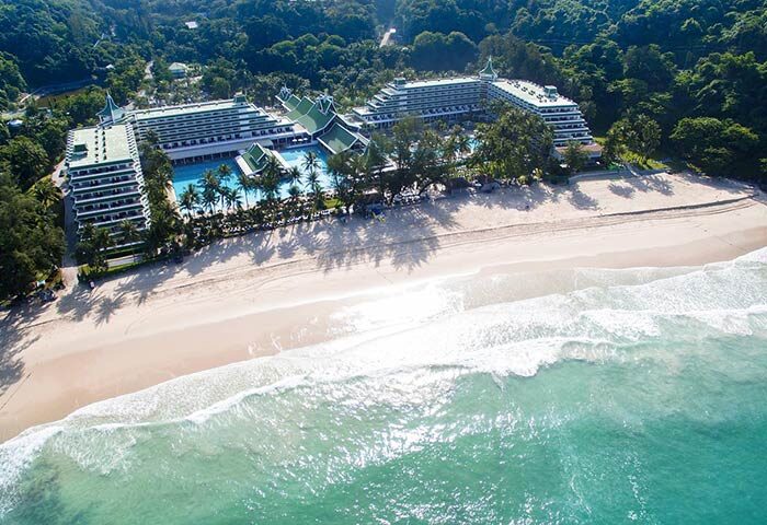 Aerial view of Le Méridien Phuket Beach Resort, a gay-friendly SHA-certified hotel. Features a beach, pools, and lush greenery.
