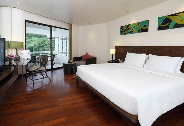 Le Meridien Phuket Beach Resort SHA Certified room. Gay-friendly hotel with a king-size bed, balcony, and modern decor. Perfect for gay travel.