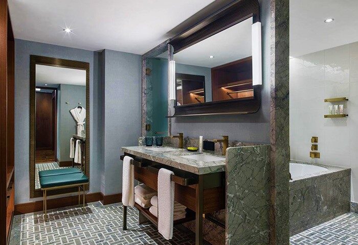 Le Meridien Seoul gay-friendly hotel bathroom. Marble countertop, large mirror, and bathtub. Luxury gay travel in Seoul, South Korea.