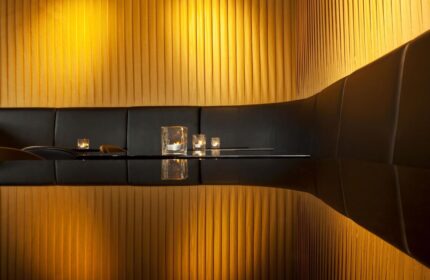 Le Méridien Vienna gay-friendly hotel interior. Black seating booth with candles and gold wall. Upscale design for gay travelers.