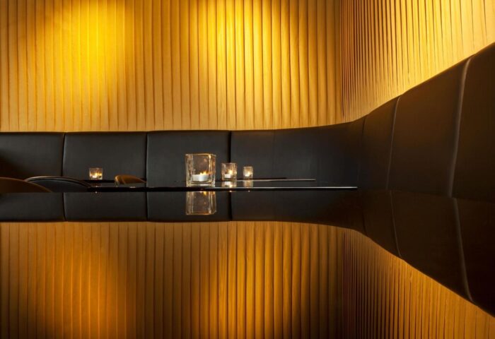 Le Méridien Vienna gay-friendly hotel interior. Black seating booth with candles and gold wall. Upscale design for gay travelers.