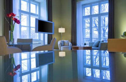 Le Méridien Vienna hotel room. Modern interior, large windows, TV, table reflection. Gay-friendly hotel for gay men travel in Vienna.
