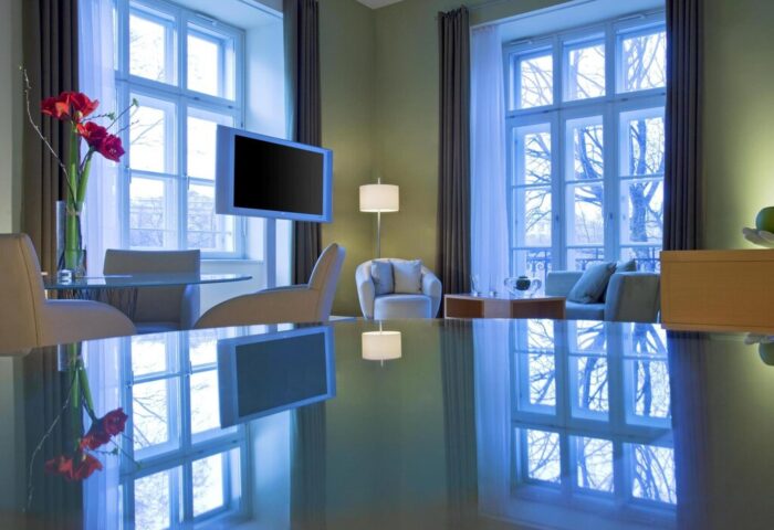 Le Méridien Vienna hotel room. Modern interior, large windows, TV, table reflection. Gay-friendly hotel for gay men travel in Vienna.