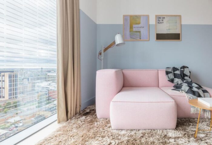 Leman Locke hotel room: pink sofa, city view, art. Gay-friendly hotel with modern design. Ideal for gay men's travel. Stylish, comfortable stay.