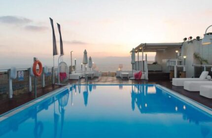 Leonardo Art Tel Aviv By the Beach: Rooftop pool at sunset. Gay-friendly hotel with lounge chairs, umbrellas, and ocean view. Perfect for gay travel.