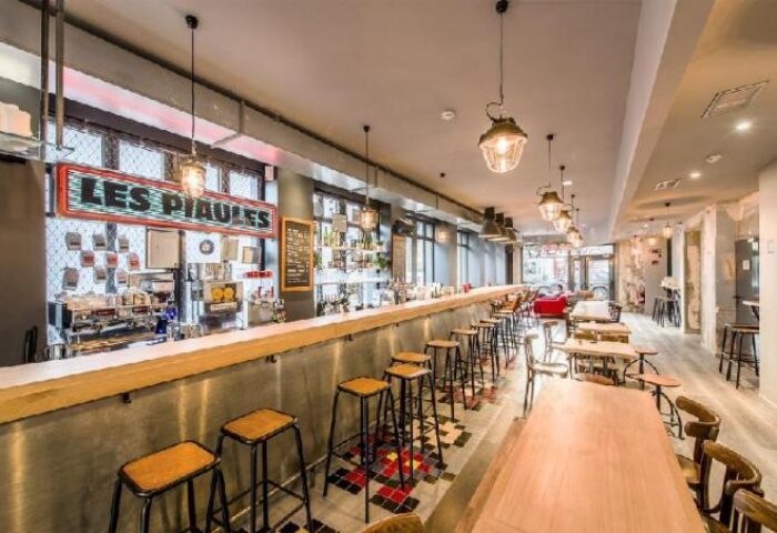 Les Piaules gay-friendly hotel bar. Long bar with stools, tables, and vintage lighting. A popular spot for gay travelers in Paris.
