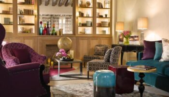 Les Tournelles gay-friendly hotel interior. Cozy lounge area with armchairs, sofa, and decorative elements. A stylish, welcoming space.