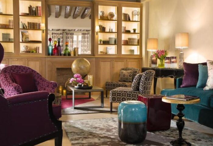 Les Tournelles gay-friendly hotel interior. Cozy lounge area with armchairs, sofa, and decorative elements. A stylish, welcoming space.