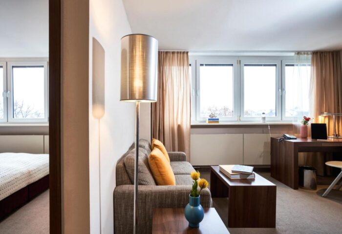 LiV'iN Residence Frankfurt Seilerstraße: Modern gay-friendly hotel room with sofa, desk, and view. Stylish living for gay travelers in Frankfurt.