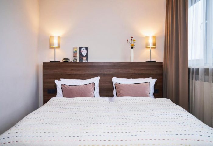 LiV'iN Residence Frankfurt Seilerstraße room. Gay-friendly hotel bed with pink pillows, lamps, and decor. Modern design, comfortable stay.